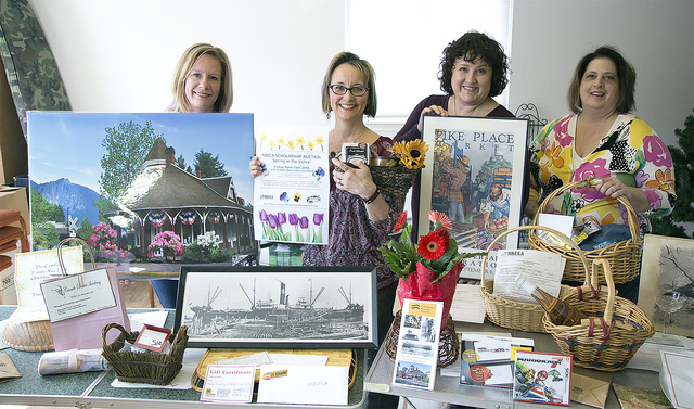 NBECA volunteers posing with table full of items for the Spring Auction